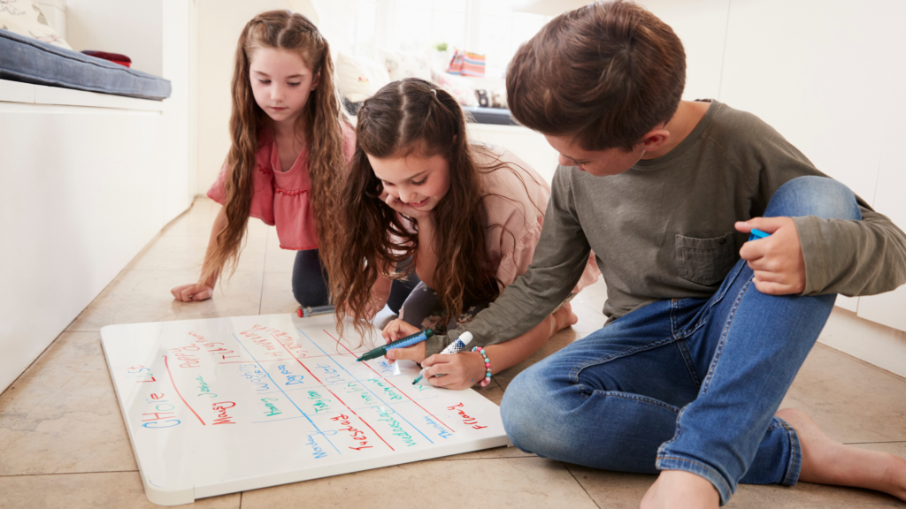 Children writing household rules on a whiteboard