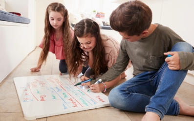 Children writing household rules on a whiteboard
