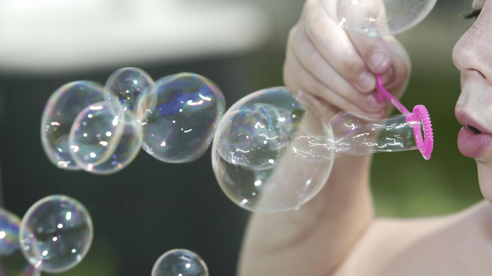 Child blowing bubbles outside